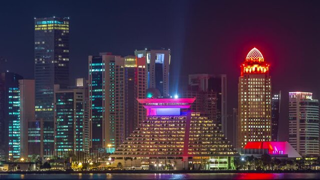 Doha skyscrapers in downtown skyline night timelapse, Qatar, Middle East Illuminated towers on a West Bay reflected in a water of Gulf.
