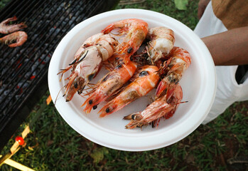focus on grilled giant river prawns serves on the white paper plate