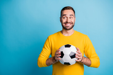 Photo portrait of man with ball smiling looking blank space curious isolated on bright blue color...
