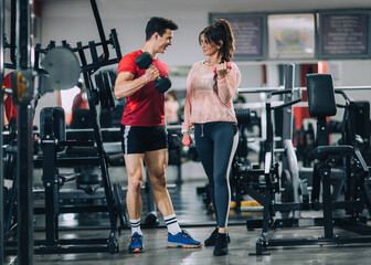 Fitness instructor with girl on training in fitness center