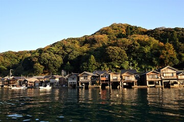 Fototapeta premium View of Funaya, boat houses, with beautiful sun light at Ine bay in Autumn , Ine city, Kyoto, Japan - 京都 伊根の舟屋 秋の景色