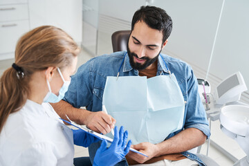 Handsome multiracial patient signing the documents