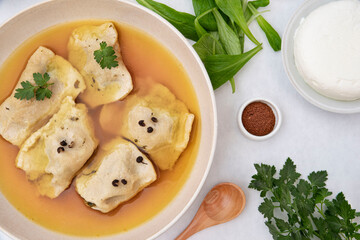 Preparation of homemade raviole in their own broth with ingredients around it