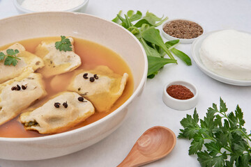 Preparation of homemade raviole in their own broth with ingredients around it