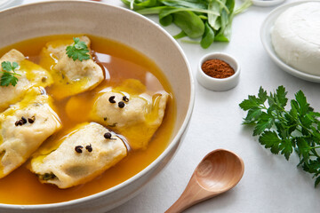 Preparation of homemade raviole in their own broth with ingredients around it