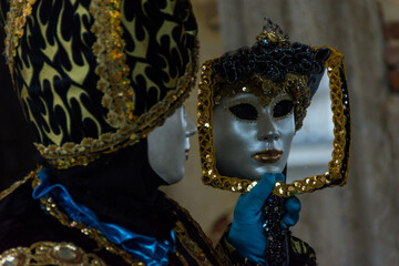 Fototapeta na wymiar Venice, Italy - February 18, 2020: An unidentified person in a carnival costume in Piazza San Marco attends at the Carnival of Venice.