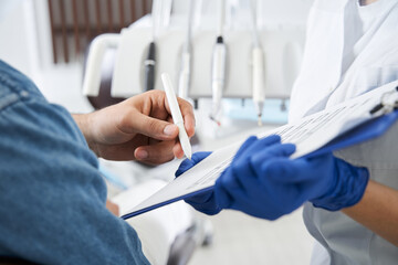 Dentist showing the form to fill in and sign before examination