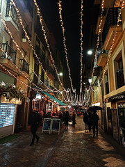 Calle iluminada con luces y guirnaldas navideñas para celebrar las fiestas navideñas.