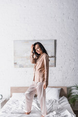 Fototapeta premium young woman standing on bed at morning
