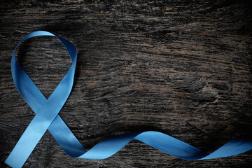 Top view of light blue ribbon on wooden background with copy space. Men's health and prostate...