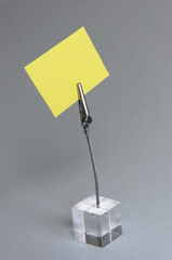 Yellow paper on a transparent cube memo holder on a white background