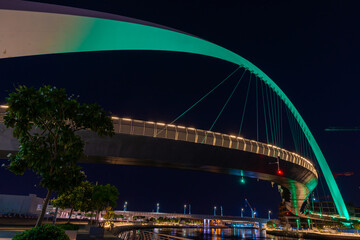 Night view to the Tolerance bridge illuminated with national green color of UAE. Amazing structure located at the Dubai water canal 