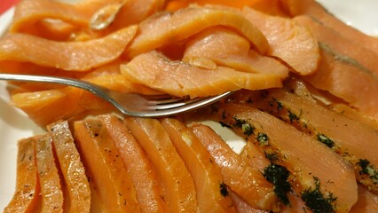 Seasoned and smoked salmon fillet sliced and served