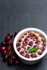Clafouti cherry pie on black stone background