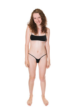 Portrait of a beautiful laughing woman wearing a black micro bikini, isolated on white studio background