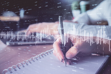 Double exposure of forex chart drawing over people taking notes background. Concept of financial analysis