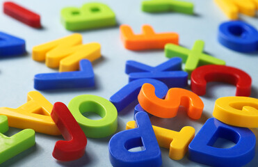 plastic colorful letters of the latin alphabet on a blue background close-up