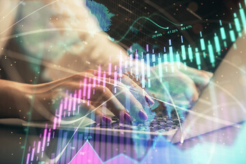 Obraz premium Double exposure of businesswoman hands typing on computer and forex chart hologram drawing. Financial analysis concept.