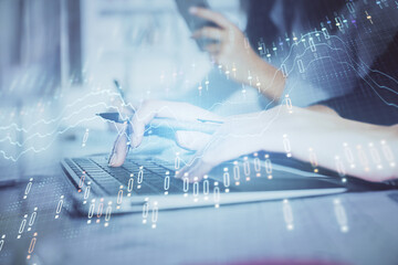 Multi exposure of woman hands typing on computer and financial graph hologram drawing. Stock market analysis concept.