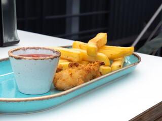 A plate of chicken nuggets with french fries