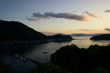 Fototapeta premium Aerial View of Ine bay and Funaya, boat houses, with beautiful sunset from Observation deck in Autumn, Ine city, Kyoto, Japan - 京都 舟屋群展望所から見た伊根湾の夕日