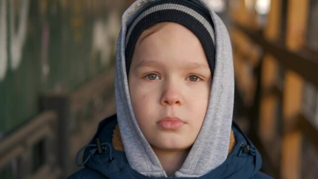 homeless orphan sad street boy looks on pityingly at camera. Waif. Hangry child