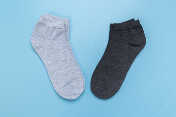 two pairs of multicolored new socks stacked on a blue background. top view.