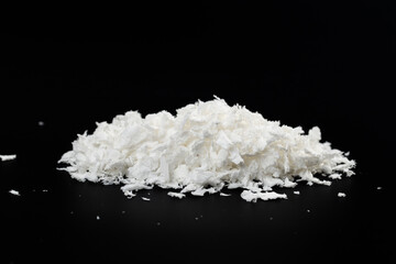 a pile of poured white artificial synthetic snow on a black background