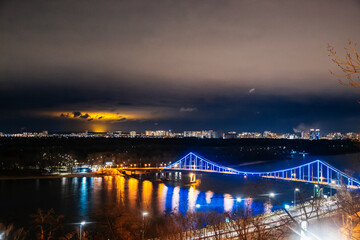 Fototapeta premium Cityscape view on the left side of Kyiv, Ukraine. The panoramic point in the touristic road. Night city with bright lights and magic atmosphere. Point view on Volodymyrska hill. 