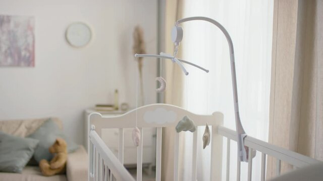 No People Slowmo Footage Of Beautiful Homemade Crib Toys Hanging Above White Baby Cot Standing In Pastel-colored Living Room