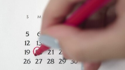 Female hand circle day in calendar date with a red marker. Business Basics Wall Calendar Planner and Organizer. APRIL 20th