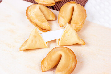 Fresh baked yellow Chinese fortune cookies on light background.