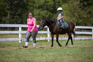 Boy riding a pony during a lesson