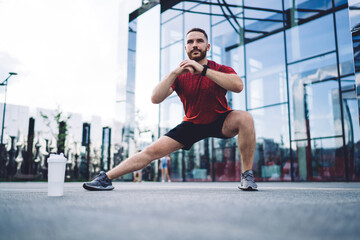 Brutal male athlete doing stretches