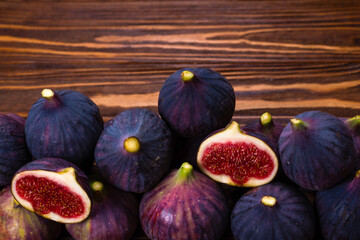 Tasty figs in a bowl on wooden background. Top view.