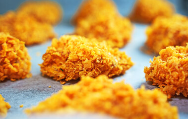 Chicken nuggets on parchment paper before baking.