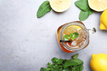 Delicious iced tea with lemon and mint on grey table, flat lay. Space for text