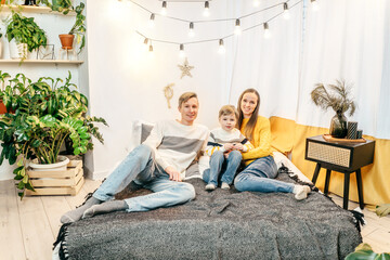 Happy family in bedroom, yellow gray colors.
