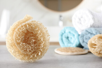 Fototapeta na wymiar Natural loofah sponge on table in bathroom. Space for text