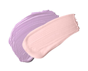 Strokes of pink and purple color correcting concealers on white background, top view