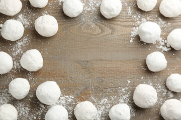 Frame of snowballs on wooden background, flat lay. Space for text