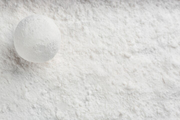 Round snowball on snow, top view. Space for text