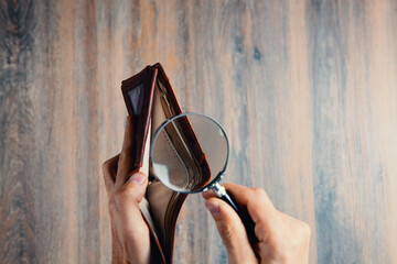 businessman holding a magnifying glass and wallet