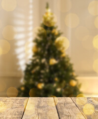 Empty wooden surface and blurred view of Christmas tree in room, space for text. Interior design