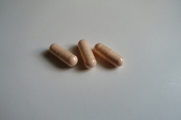 Group of three pink capsules of probiotic dietary supplement