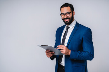 Successful Arabian businessman with clipboard isolated over grey background