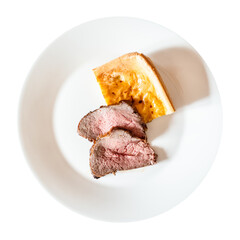 top view of homemade sliced Roast Beef and piece of Yorkshire pudding on white plate cut out on white background