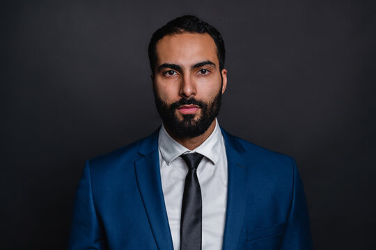 Serious arab businessman in formal attire isolated over black background