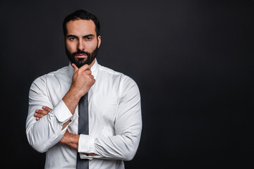 Pensive arab businessman in formal clothing isolated over black background