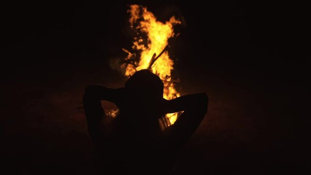 Silhouette of mystic woman in black background of fire fly flame, spark, of contour outline. Adult sexy of young girl witchcraft ceremony ritual dance in underclothes. Outdoor slow motion. Caucasian.